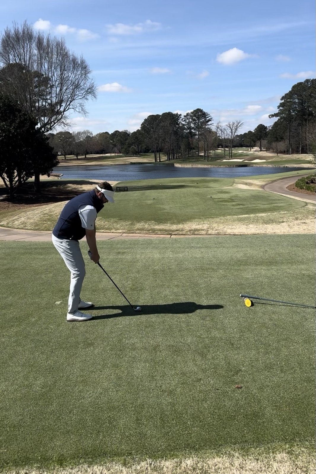David addressing a tee shot above a lake